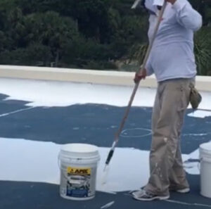 rolling elastomeric roof coating on commercial roof by a Tucson roof coating specialist