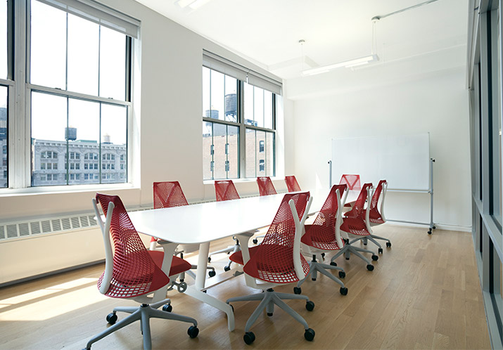 Conference room with large table, seating and oversized windows at a NYC office space for rent in Flatiron Manhattan.