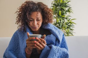 woman feeling sick and drinking tea