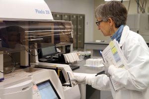 A scientist trains on a new tool in a lab.