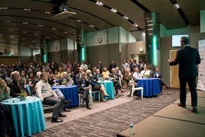 The CEO of StartUp Health speaks to a crowd in a conference room about health innovation.