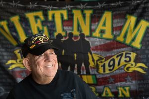 J.D. Hill at his home with a Vietnam Veteran flag behind him.