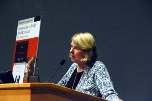 Kay Redfield Jamision speaks at a lecture at the Anschutz Medical Campus about what it's like to have bipolar disorder. She's at a lectern speaking with a sign about her lecture in the background.