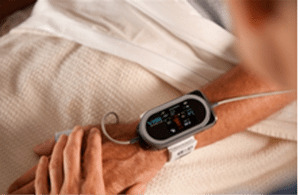 A photo of a medical wearable watch on a patient's wrist.
