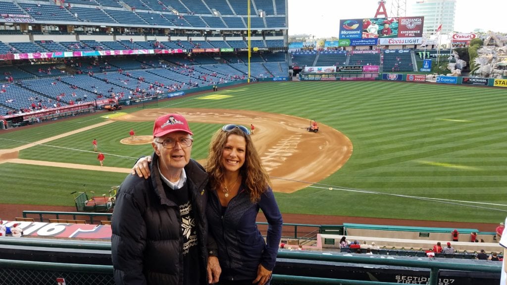 Louisa Drouet poses with her dad. They're at a baseball game in Los Angeles. Drouet lost her dad a year ago. She's been coping with breast cancer since his death.
