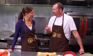 Louisa Drouet was a broadcaster for many years. Here she does a cooking segment. She's wearing an apron and interviewing a chef.