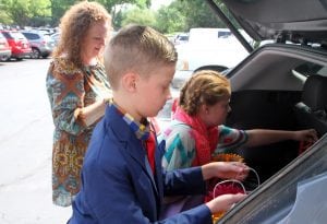 Charlie and his family unload care packages from their care.