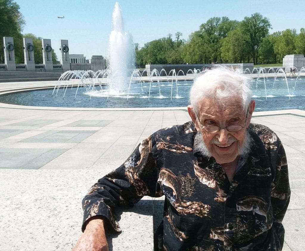 94-year-old WW II veteran Virgil Hughes stands in front of a fountain at the WW II Memorial in Washington, D.C.