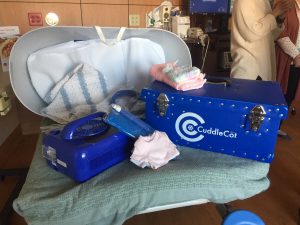 photo shows a device called a Cuddle Cot. It's a cooling bassinet that makes it possible for familes to spend more time with infants who have died before or just after birth