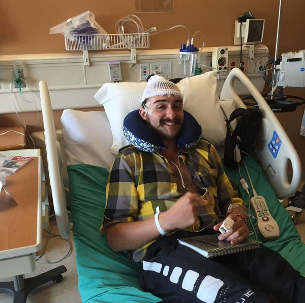 Kyle Parker recovers in a hospital bed after brain surgery.
