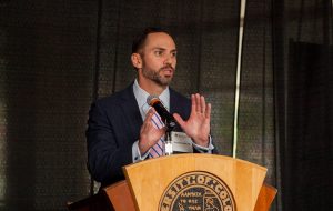 Dr. Armando Vidal speaking at a lectern.