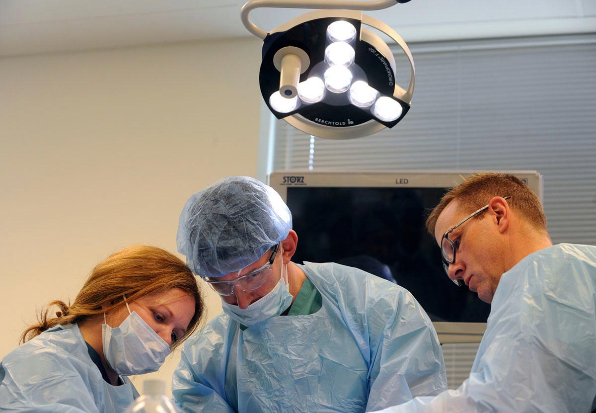 three people working around an OR table