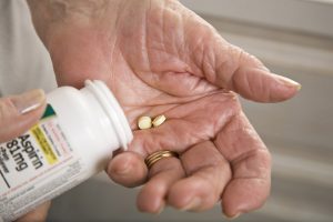 An older person takes baby aspirin.