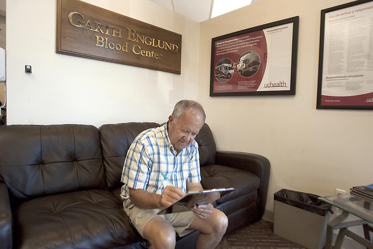 Simon fills out paperwork on the couch at the blood donation center.