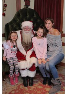 Sarah Hugo is photographed with two girls and Santa Claus
