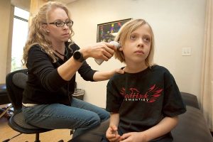 Brandi, a two-time living donor, looking in a child's ear.