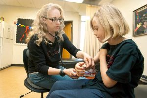 brandi, a two-time living donor, examines a student's armn
