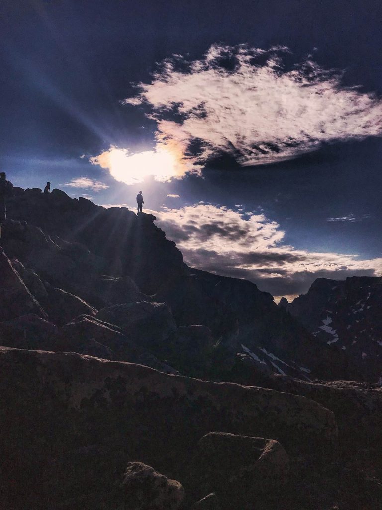Nathan Kissack in silhouette on a rocky outcropping near the summit of Cloud Peak in Wyoming.