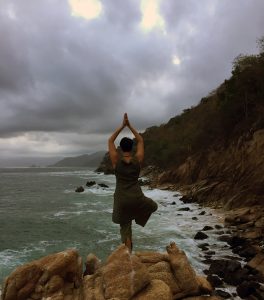 Alex Mathisen practices yoga on rocks overlooking the ocean in Mexico.