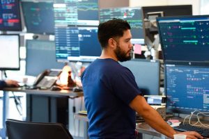 nurse looks at a bunch of computer screens with health information on them which is part of sepsis interventions..