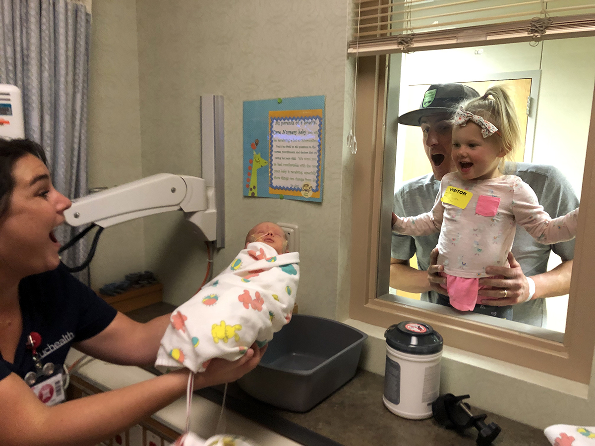 In this photo, big sister Eddy McDaniel looks at her new sister, Mimi, through a window.