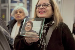 Woman holds up photo of her sister, who didn't want to die in the ICU and was instead taken out of the hospital to witness one last sunrise.