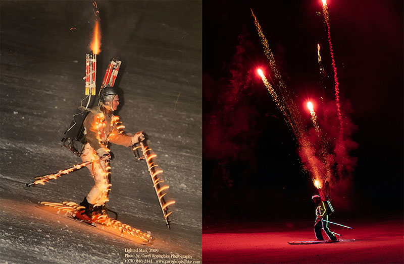 A man skis at night with lights and fireworks strapped to him in this photo.