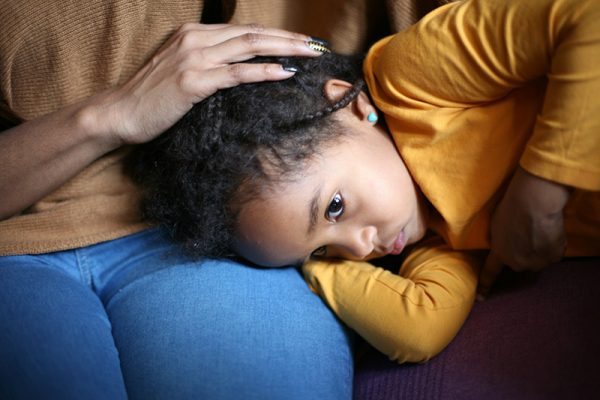 A sick child on her mom's lap. Flu season in 2020 has been especially hard on children.