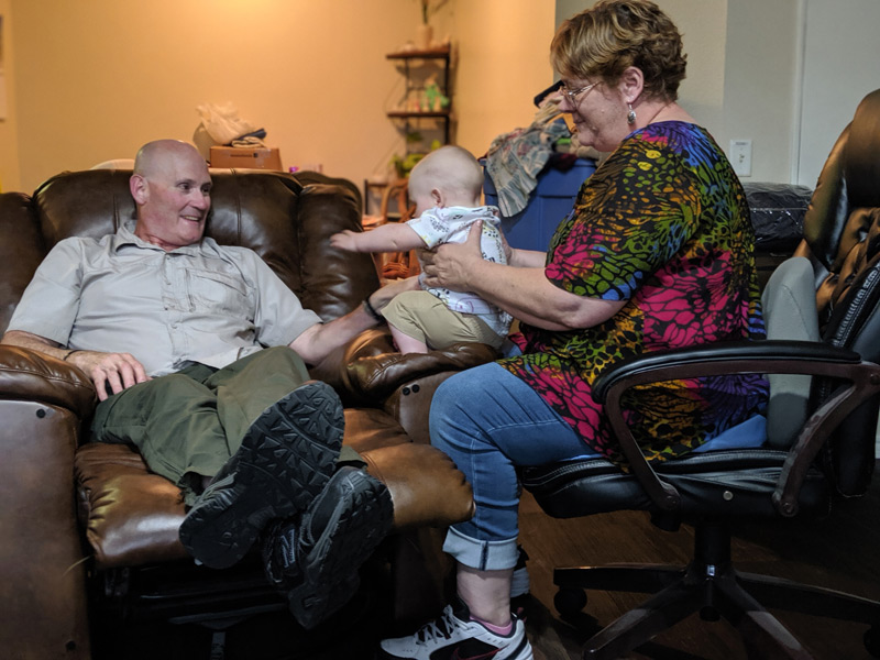 couple plays with their grandbaby in living room, something the grandfather might not be able to enjoy it it wasn't for CarioMems device that monitors his heart.