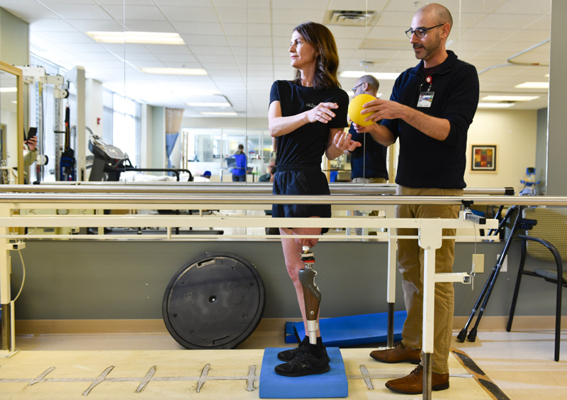 physical therapist works with woman after her osseointegration surgery.