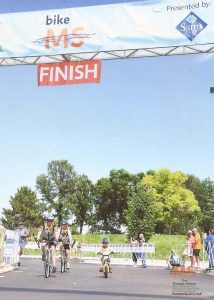 The Malone family crosses the finish line of a bike race in this photo.