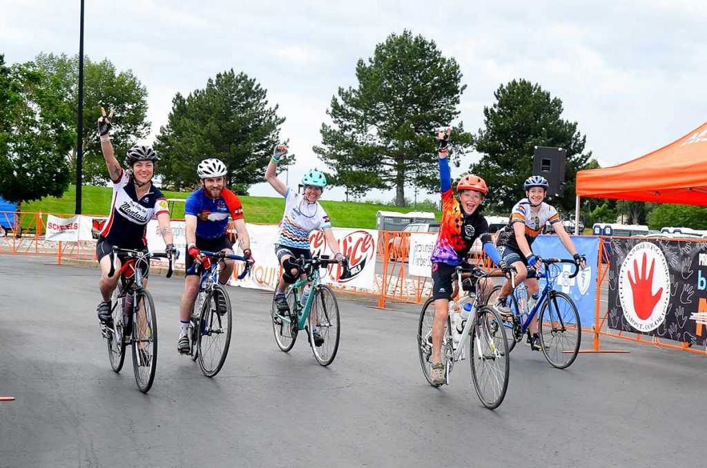 Lane Malone, her son, Sal, and other riders cross the finish lane of the Bike MS ride in this photo.