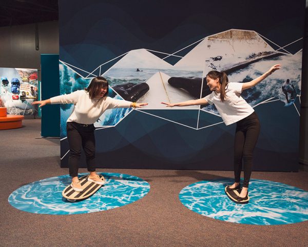 young women enjoy an exhibit on extreme sports at the Denver Museum of Nature and Science during free days at denver cultural institutions.