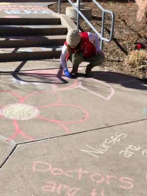 Volunteers chalk messages of gratitude outside hospital ...