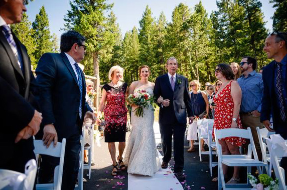 Dr. Michael Douglas and his wife, Meg, walk their daughter down the aisle at her wedding. Michael is the first patient in Colorado to have received convalescent plasma to help fight COVID-19.