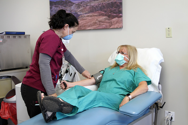 phlebotomist readies Julie for plasma donation, which will be used for COVID patients in Colorado