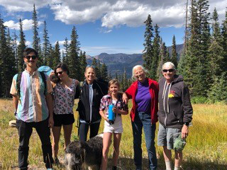 family lined up in meadow in the mountains on a sunny day.