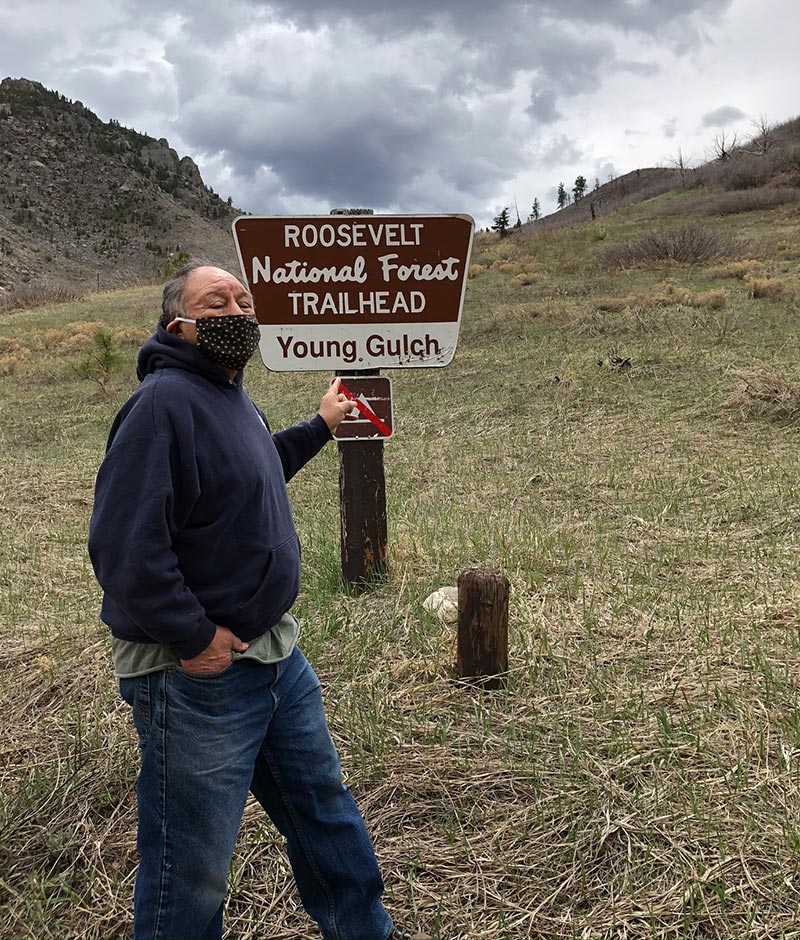 sam standing in front of a trailhead sign.