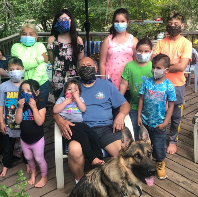 Sam with grand kids on porch all wearing masks
