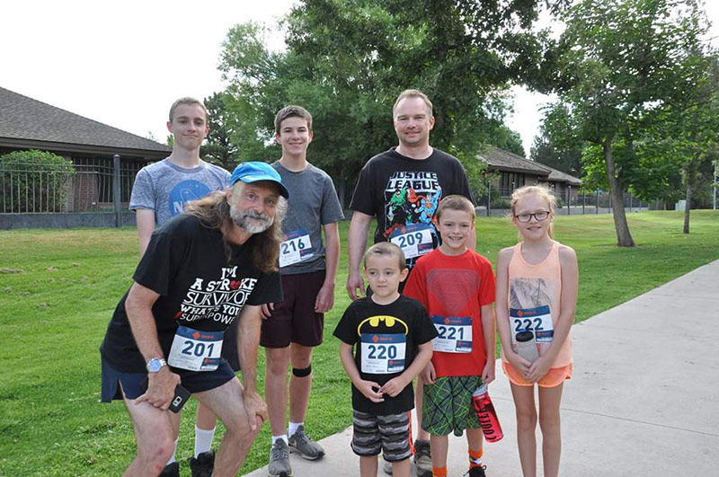 Jeff with his grandkids, all wearing race numbers.