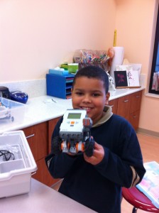 A young boy holds up a robot