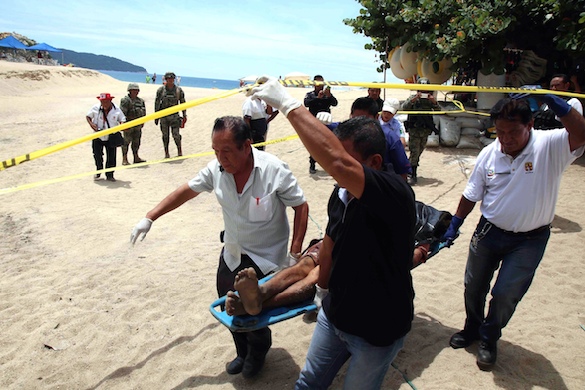 Trabajadores del Semefo trasladan el cuerpo del hombre asesinado a balazos en la playa El Morro t Foto: Carlos Alberto Carbajal
