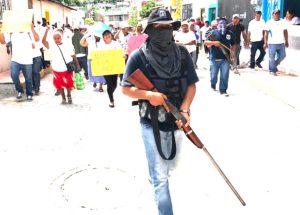 Un policía comunitario vigila la marcha de pobladores de nueve comunidades en Zumpango, que exigieron seguridad  . Foto: Lenin Ocampo Torres 