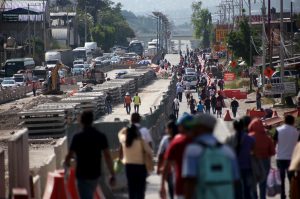 Transeúntes caminan en la Autopista del Sol en el crucero a Chichihualco, donde se construye un puente elevado y padres de familia del jardín de niños María Montessori bloquearon la vialidad para exigir la reconstrucción de su escuela. Foto: Eric Chavelas Hernández