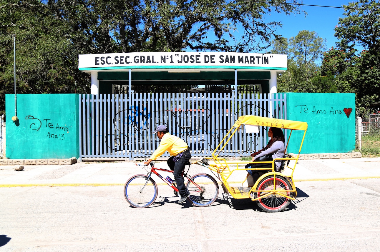 Un bicitaxista en la calle Insurgentes, de Chilapa, pasa frente a la escuela secundaria general número 1 José de San Martín. Sólo en la cabecera municipal hay 64 escuelas cerradas ante las amenazas de la delincuencia organizada que opera en esta zona, según el gobernador, Héctor Astudillo. Foto: Jesús Eduardo Guerrero
