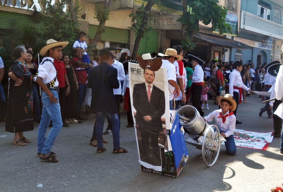 Alumnos de secundaria de Atoyac caracterizados como revolucionarios, escenifican el fusilamiento de un cartel con la fotografía del presidente Enrique Peña Nieto, durante en el desfile conmemorativo del centésimo sétimo aniversario de la Revolución Mexicana. Foto: Francisco Magaña