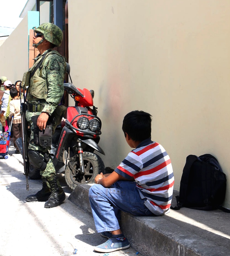 Un niño observa a un militar en la salida de la Primaria Federal Justo Sierra en el centro de Chilapa. Foto: Luis Daniel Nava.