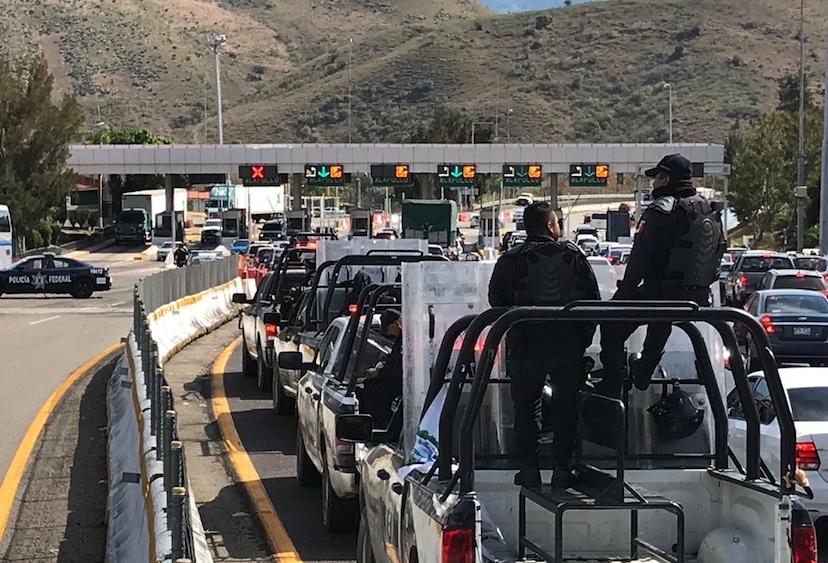 Un convoy de policías estatales llega a la caseta de Palo Blanco de la Autopista del Sol, que normalistas de Ayotzinapa tomaron una hora para pedir dinero para continuar con el movimiento por la presentación con vida de los 43 desaparecidos. Foto: Lenin Ocampo Torres