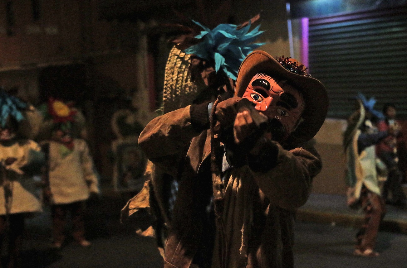 Tlacololeros de Chilpancingo danzan en una calle de la capital rumbo a la Catedral de Santa María de la Asunción la noche del 24 de diciembre, donde se reúnen en el atrio para bailar, como un homenaje navideño. Foto: José Luis de la Cruz