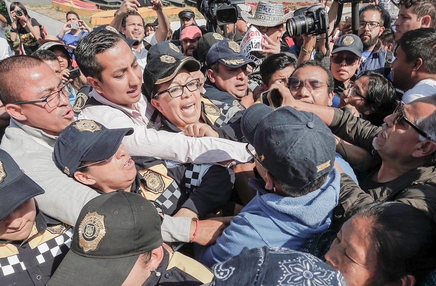 Estudiantes, activistas y padres de los 43 estudiantes desaparecidos de Ayotzinapa bloqueados por policías a la entrada de la basílica de la virgen de Guadalupe, durante una protesta para exigir respuestas al gobierno mexicano, el martes, en la Ciudad de México. EFE/José Méndez